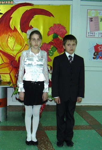 Лысенко Анна, Петерс Ростислав несут почетный караул на посту №1 у импровизированного Вечного огня в фойе школы.
